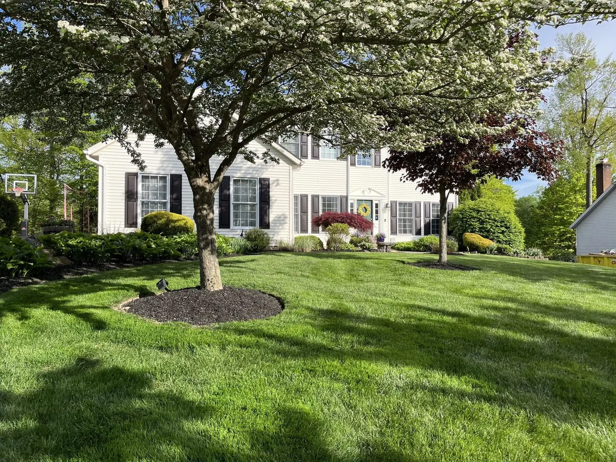 Tan home with curved bed and lush lawn