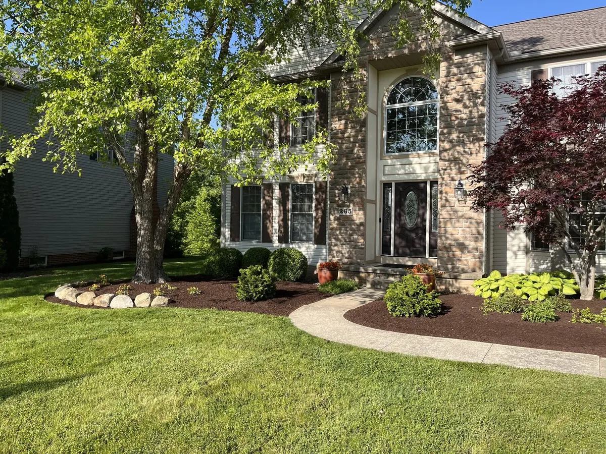 Front yard with bold mowing stripes leading up to colonial home